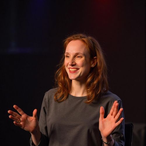 Showcase image for Inspirational Speaker - Prompt: a photo of me WOMAN as an inspirational speaker, medium shot, with an uplifting, hopeful expression, warm stage lighting. WOMAN looking motivating.