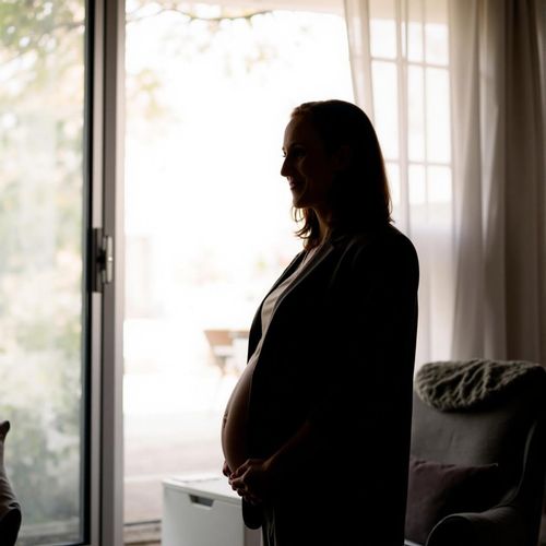 Showcase image for Elegant Silhouette - Prompt: a silhouette of me WOMAN, pregnant, against a bright window, half body shot. the shape of her body is the focus.