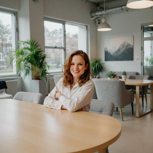 Showcase image for Collaborative Space - Prompt: a photo of me WOMAN in a bright, open-plan office, medium shot, leaning against a communal table. WOMAN looking friendly and collaborative.