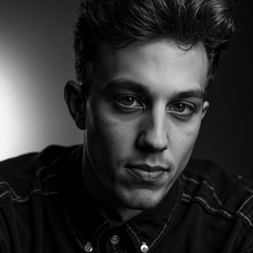 a black and white portrait of me MAN, close-up, with one half of their face in deep shadow. MAN looking intense.