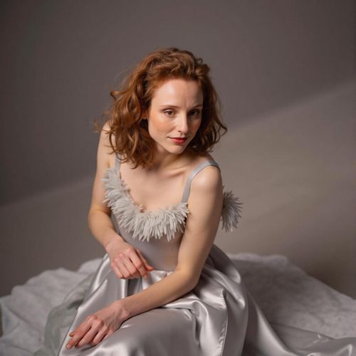 Showcase image for Vintage Glamour - Prompt: a photo of me WOMAN in a classic satin slip with feather trim, medium shot, posing like a 1940s movie star. WOMAN with a glamorous gaze.