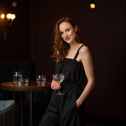 Showcase image for Cocktail Lounge Chic - Prompt: a photo of me WOMAN in a sophisticated outfit at an upscale cocktail lounge, medium shot, holding an elegant drink, dim, moody lighting. WOMAN looking chic and refined.