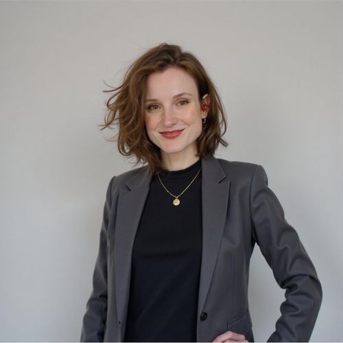 Showcase image for Professional Headshots - Prompt: a photo of me WOMAN in a sharp business suit, classic headshot, plain studio background, looking confident. WOMAN making direct eye contact.