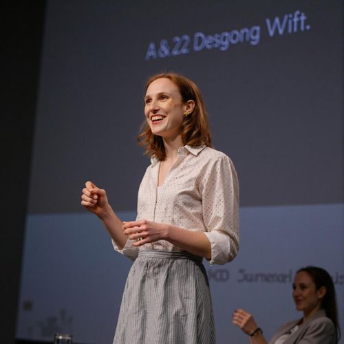 Showcase image for On Stage - Prompt: a photo of me WOMAN on a stage, giving a presentation, medium shot. WOMAN looking passionate and engaging.