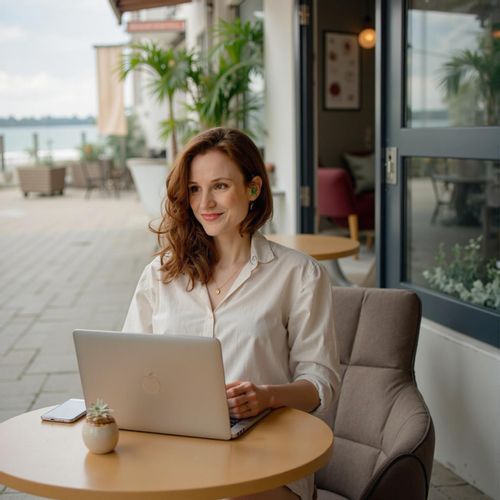 Showcase image for Remote Work Lifestyle - Prompt: a photo of me WOMAN working on a laptop at a beachside cafe, half body shot, looking focused but relaxed. WOMAN living the dream.