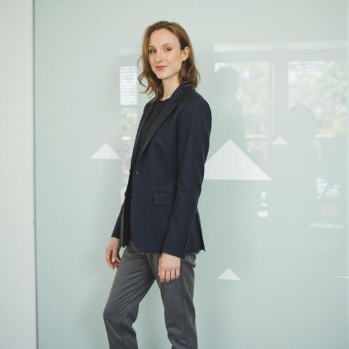 Showcase image for Tech Innovator - Prompt: a photo of me WOMAN in modern, minimalist attire, medium shot, against a backdrop with subtle tech-related geometric patterns. WOMAN looking visionary.