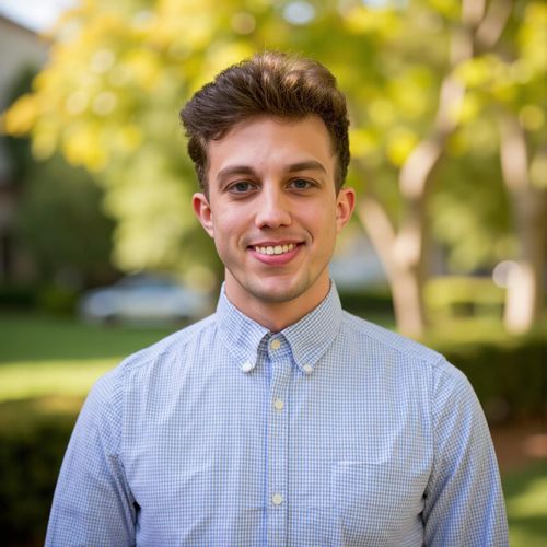 Showcase image for Local Expert - Prompt: a photo of me MAN, real estate agent headshot, medium shot, with a subtly blurred background of a charming local park. MAN looking like a community expert.