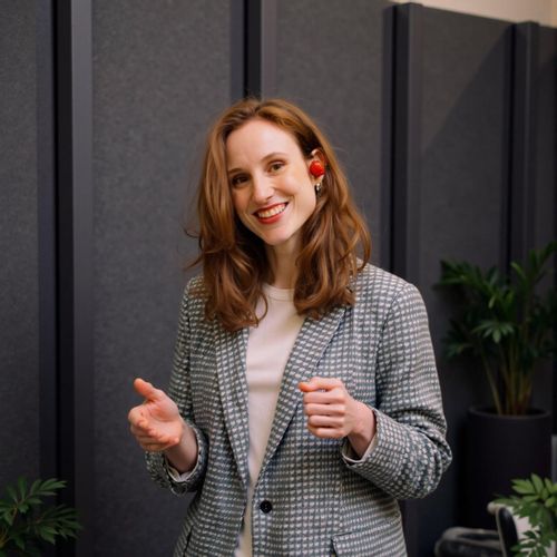 Showcase image for Engaging The Audience - Prompt: a photo of me WOMAN as a keynote speaker, medium shot, smiling warmly at the (implied) audience, open and inviting posture. WOMAN looking approachable.