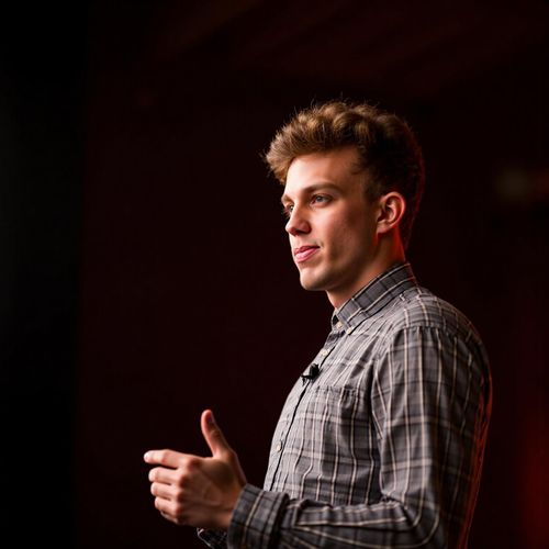 Showcase image for Inspirational Speaker - Prompt: a photo of me MAN as an inspirational speaker, medium shot, with an uplifting, hopeful expression, warm stage lighting. MAN looking motivating.
