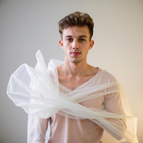 Showcase image for Ethereal Glow - Prompt: a photo of me MAN in flowing, light-colored fabric, half body shot, soft, diffused lighting creating an ethereal glow. MAN with a serene, dreamy expression.