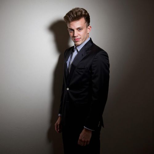 a photo of me MAN, elegantly dressed, half body shot, partially obscured by shadow. MAN looking alluring and dangerous.