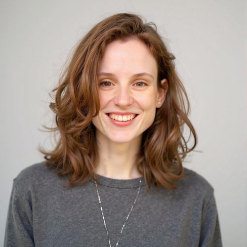 Showcase image for Trusted Advisor - Prompt: a photo of me WOMAN, real estate agent headshot, medium close-up, wearing professional attire with a warm smile, against a clean studio background. WOMAN looking trustworthy.