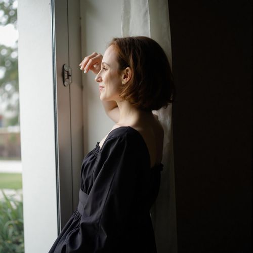 Showcase image for Film Noir - Prompt: a photo of me WOMAN, elegantly dressed, half body shot, partially obscured by shadow. WOMAN looking alluring and dangerous.