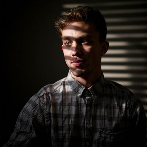 a photo of me MAN in a dimly lit office, half body shot, shadows from window blinds striping the scene. MAN looking thoughtful.