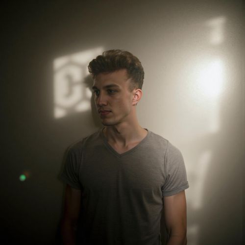 a photo of me MAN in a smoky room, the light filtering through in beams, half body shot. MAN looking contemplative.